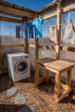 image-showcases-outdoor-laundry-area-featuring-white-washing-machine-placed-gravel-surface-ab...jpeg